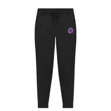 Load image into Gallery viewer, Flaylay of Be Happy black joggers from the Pink Runway Bright Future range. There is a drippy smiley face in pink/purple under the left pocket.