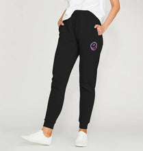 Load image into Gallery viewer, Close up of lady wearing black jogging bottoms with pink/purple drippy smiley face just underneath the left pocket. This is from the Pink Runway Bright Future range.